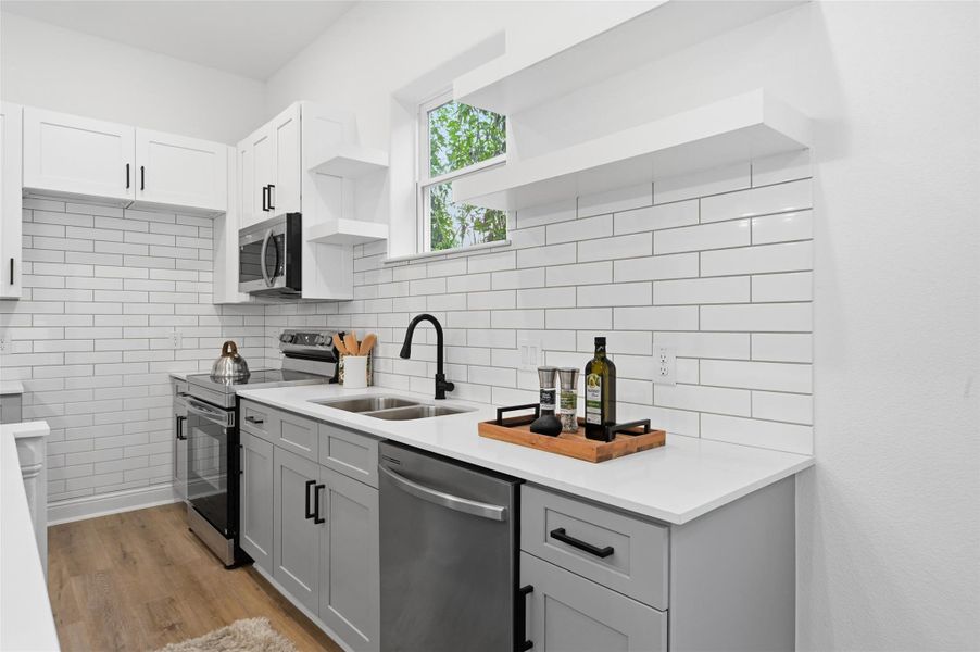 Open concept kitchen, dining and living room, with lots of natural light.
