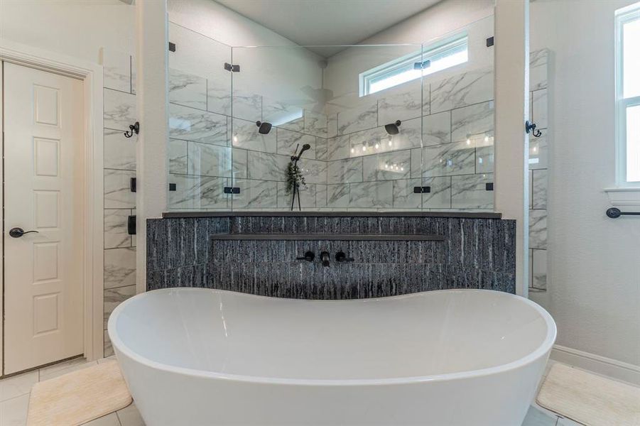 Full bath featuring a freestanding bath, light tile patterned floors, and a stall shower Full bath featuring a freestanding bath, light tile patterned floors, and a stall shower
