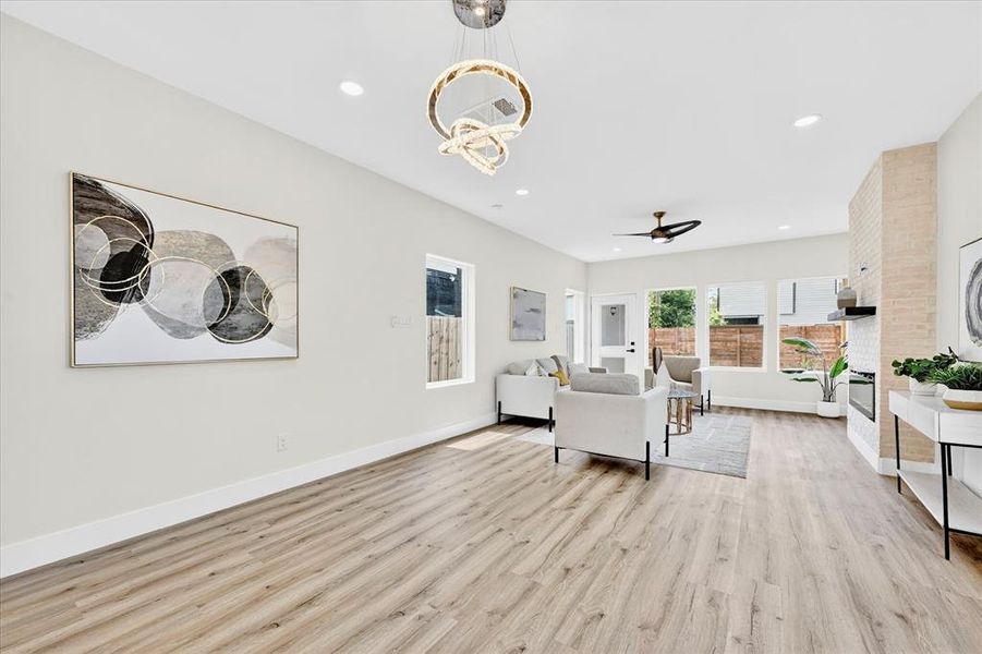 Bright interior space featuring wood-finish flooring, recessed lighting, and a contemporary chandelier