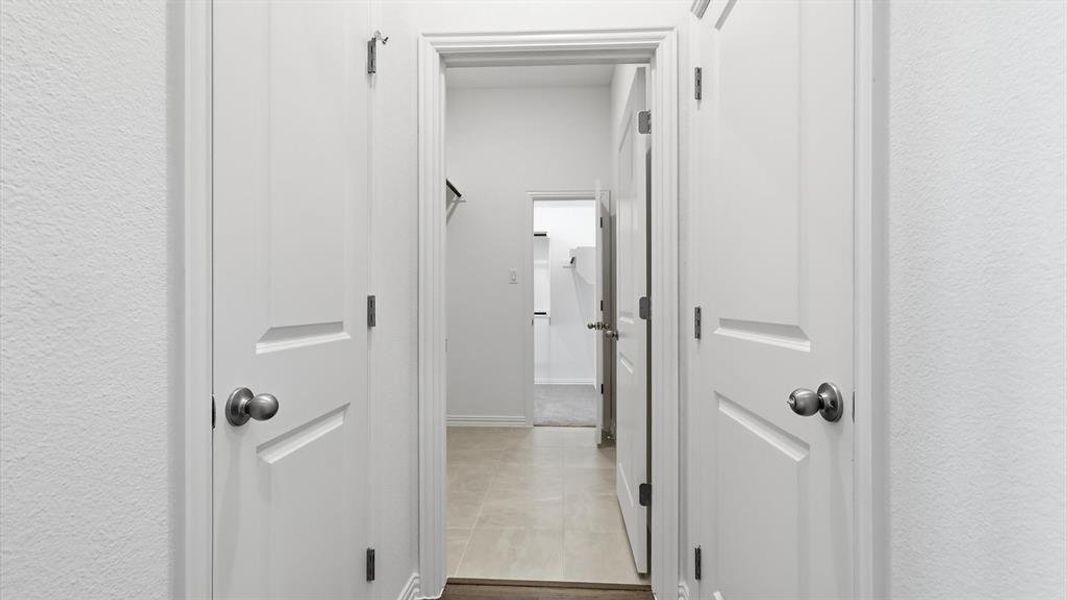Hallway featuring multiple white paneled doors with satin nickel hardware