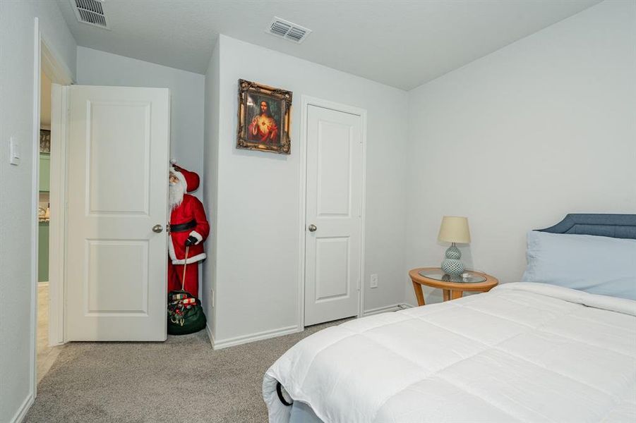 Carpeted bedroom with lofted ceiling, baseboards, and visible vents