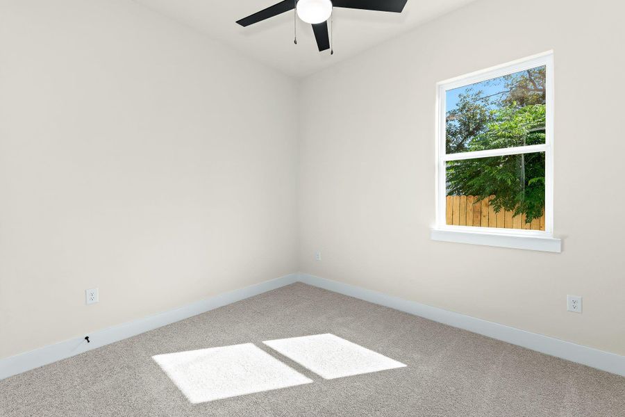 Carpeted empty room with baseboards and a ceiling fan