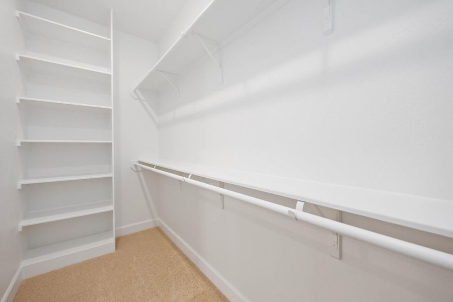 One of two walk-in closets in the primary suite—complete with built-in shelving to keep everything tidy and within reach.