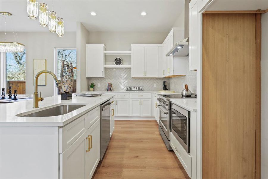 Kitchen with white cabinets, light countertops, and a sink