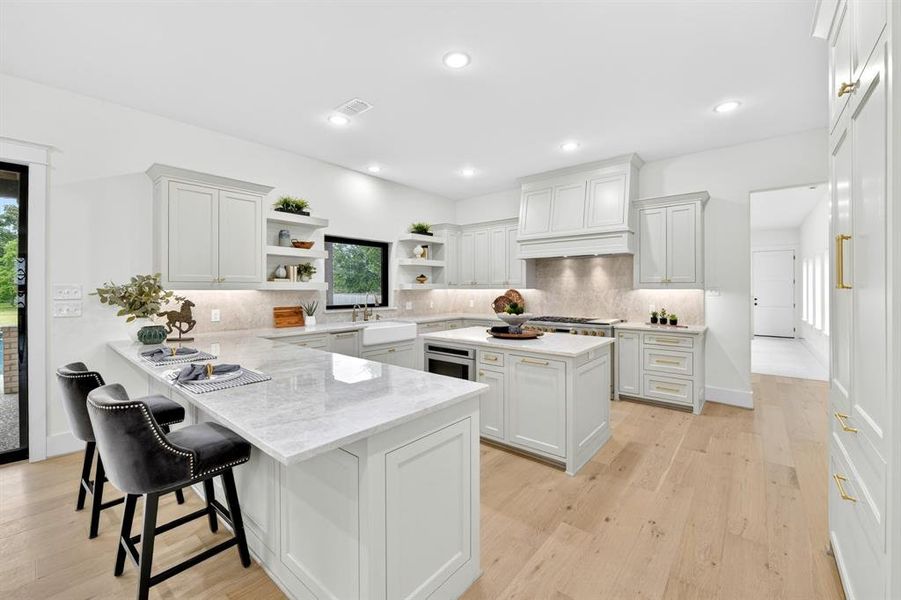 Chef's dream kitchen complete with a monogram gas and electric range and a Thermidor built-in smart refrigerator with quartz countertops and backsplash Chef's dream kitchen complete with a monogram gas and electric range and a Thermidor built-in smart refrigerator with quartz countertops and backsplash