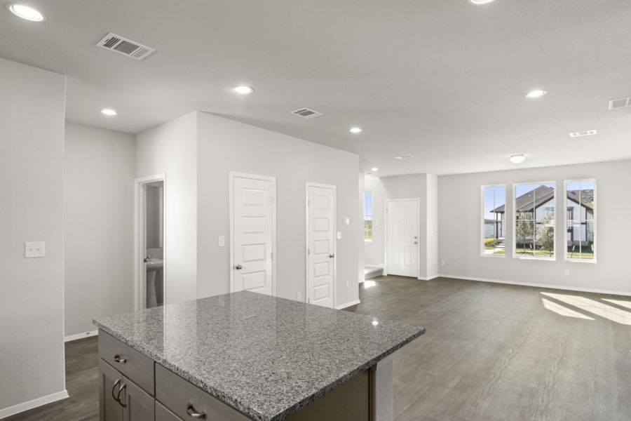 Image of a kitchen with a granite center island overlooking the living room and dining area