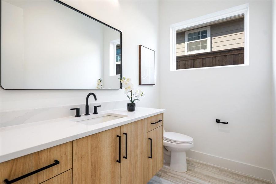 Bathroom featuring wood-type flooring, vanity, and toilet