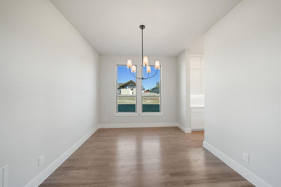 Unfurnished dining area with a chandelier and light wood-type flooring Unfurnished dining area with a chandelier and light wood-type flooring