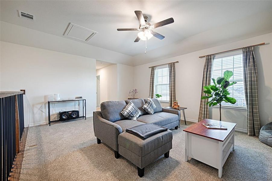 Living room with carpet flooring and ceiling fan