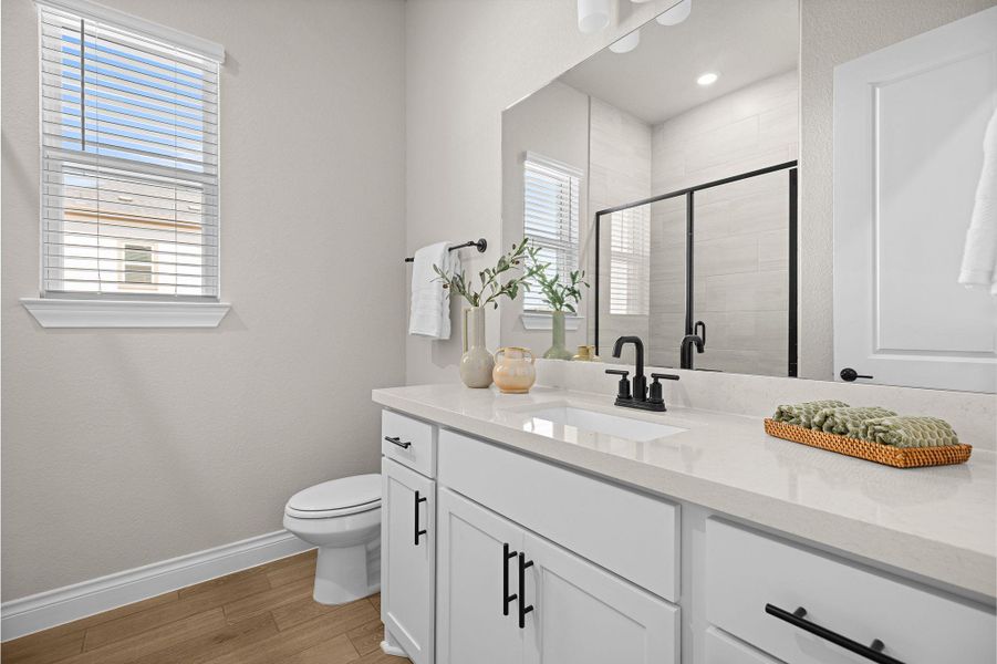Full bath featuring a shower stall, light wood finished floors, and vanity