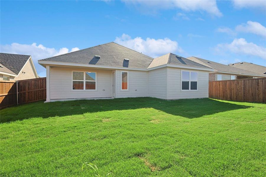 Rear view of property with a yard