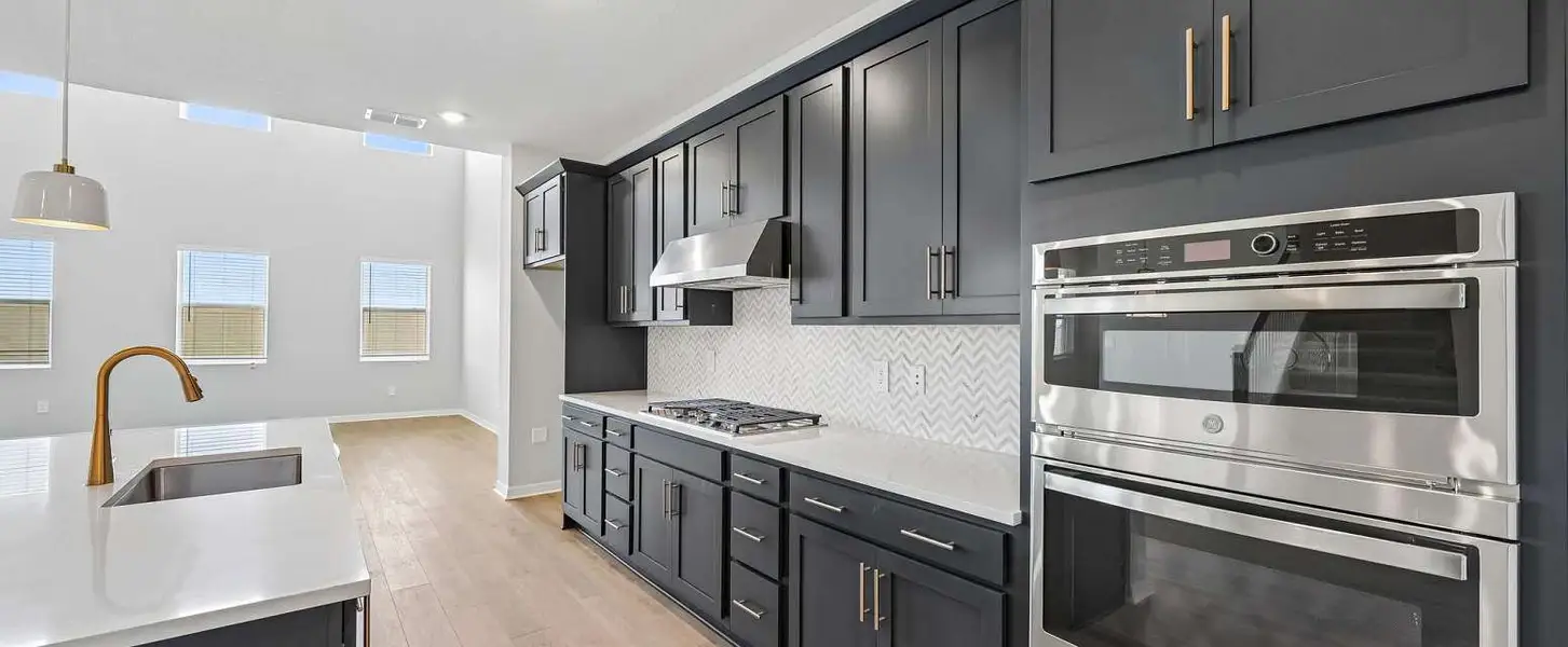 Kitchen featuring the gourmet kitchen layout - double stack oven and microwave, vent hood and flat range - Representative images and renderings are for illustrative purposes this home will feature AW Studio Collection® Harmony