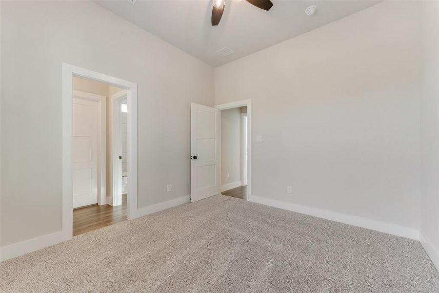 Carpeted empty room with ceiling fan