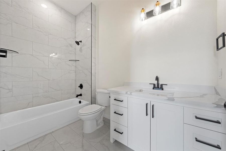 Bathroom with vanity, shower / tub combination, and light marble finish floors