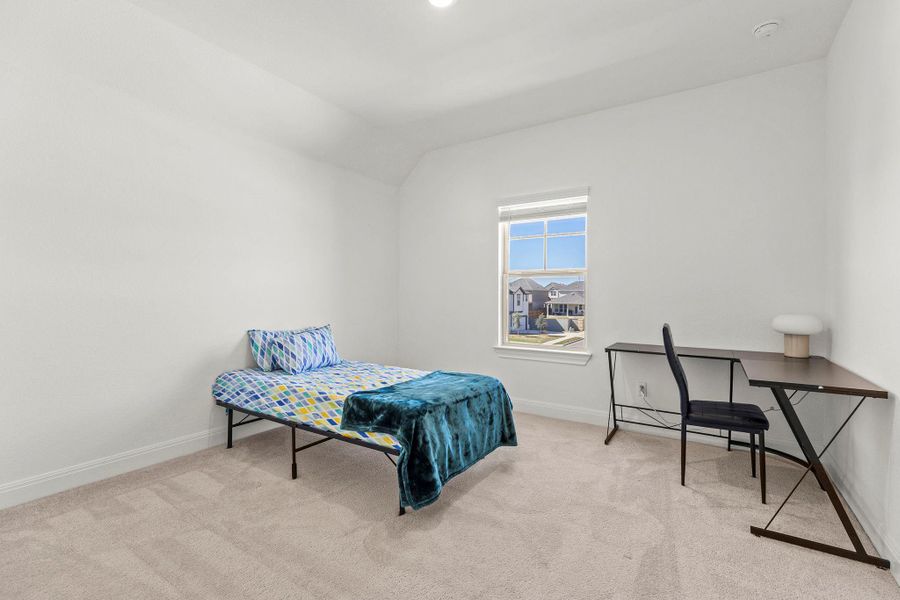 Bedroom with light colored carpet and lofted ceiling