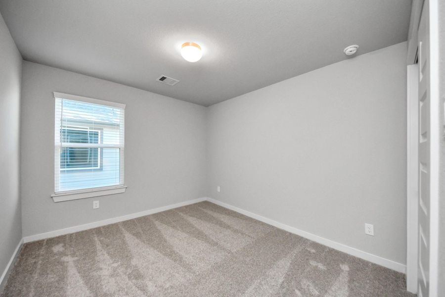 Generously sized secondary bedrooms featuring spacious closets, soft and inviting carpeting underfoot, large windows allowing plenty of natural light, and the added touch of privacy blinds for your personal retreat. Sample photo of completed home with similar floor plan. Actual colors and selections may vary.