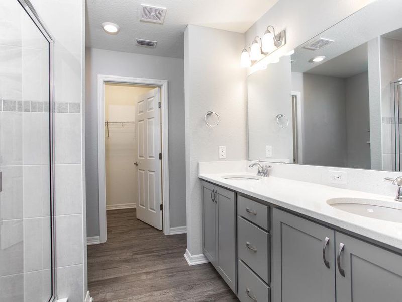 Complete with en-suite owner`s bath with dual vanities, a tiled shower, and linen shelves - Seabrooke ll home plan by Highland Homes