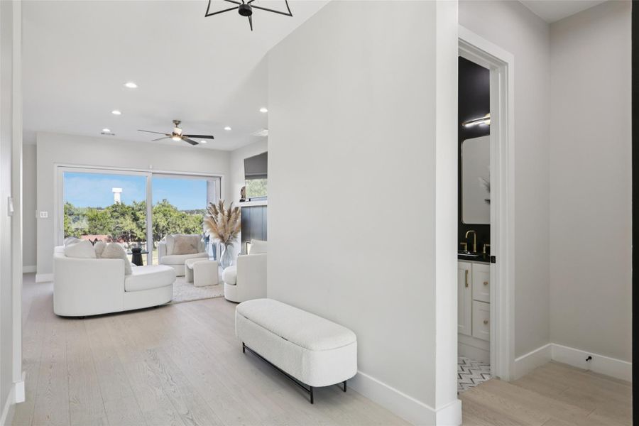Living room with light wood finished floors, recessed lighting, and a ceiling fan