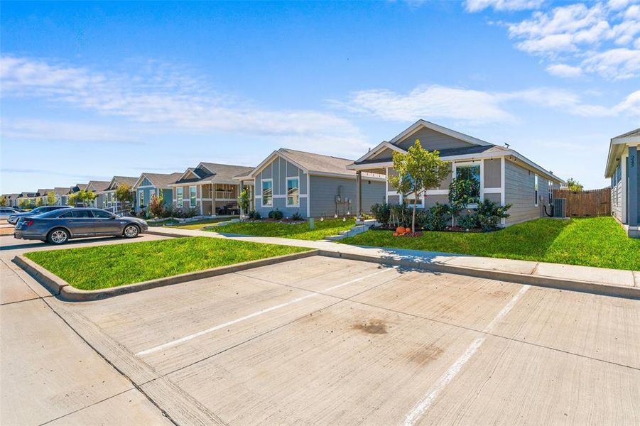 View of front of property featuring a front lawn, uncovered parking, and a residential view View of front of property featuring a front lawn, uncovered parking, and a residential view