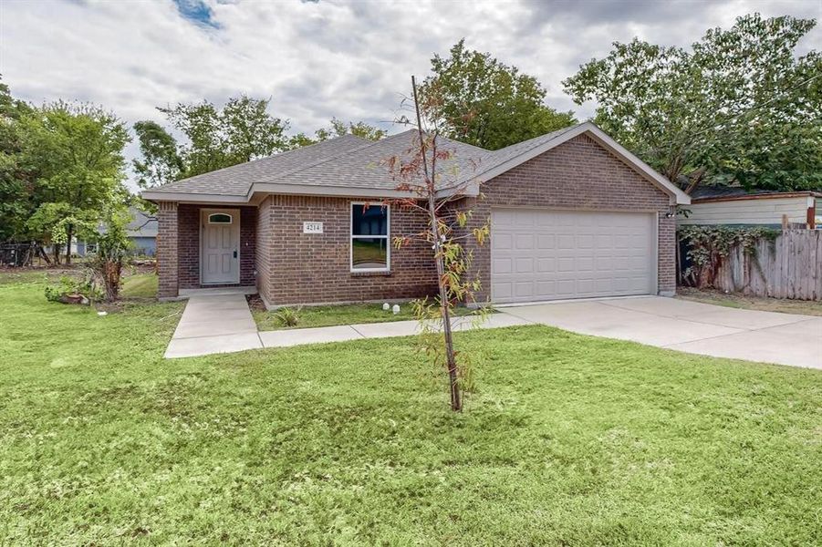 Ranch-style house with a garage and a front lawn