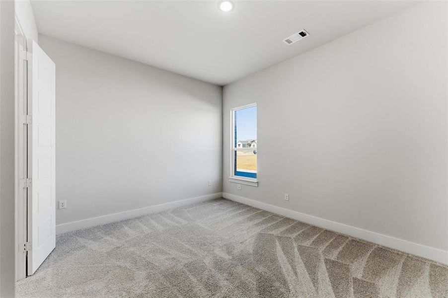Unfurnished bedroom with light colored carpet and recessed lighting