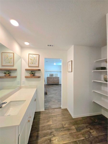 Bathroom vanity featuring a single sink, light-toned countertop, and white cabinetry