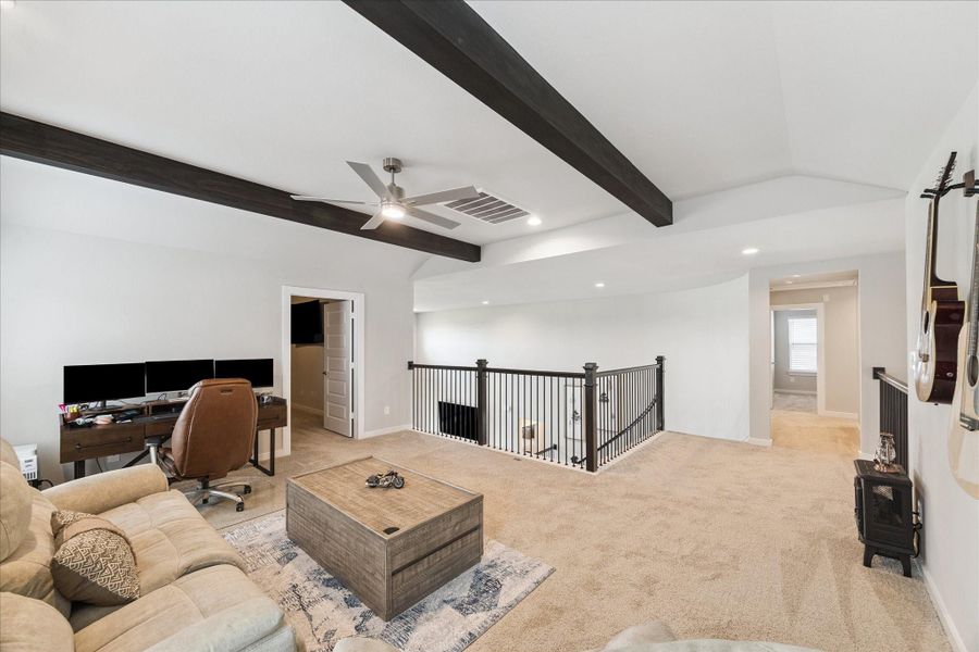 Spacious den featuring neutral carpet, white walls, and dark wooden beams on the ceiling. Spacious den featuring neutral carpet, white walls, and dark wooden beams on the ceiling.