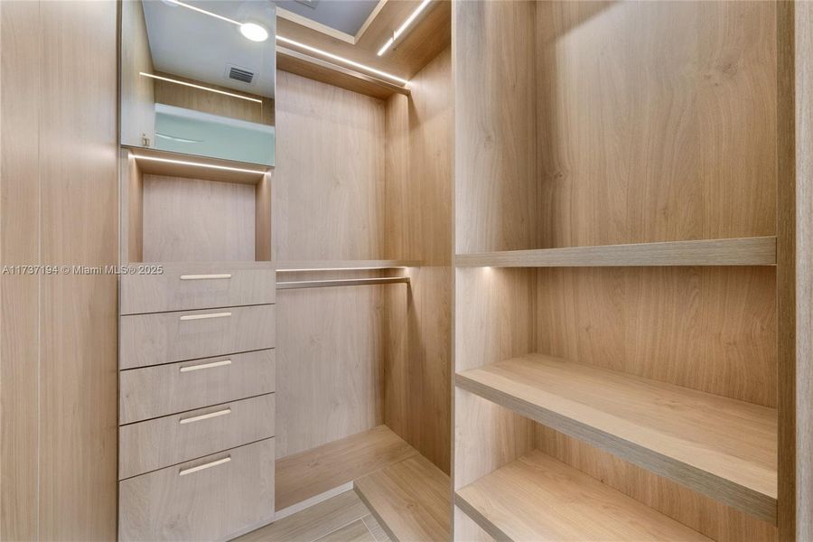 The primary bedroom features a custom Italkraft walk-in closet with LED lighting and thoughtfully designed storage.