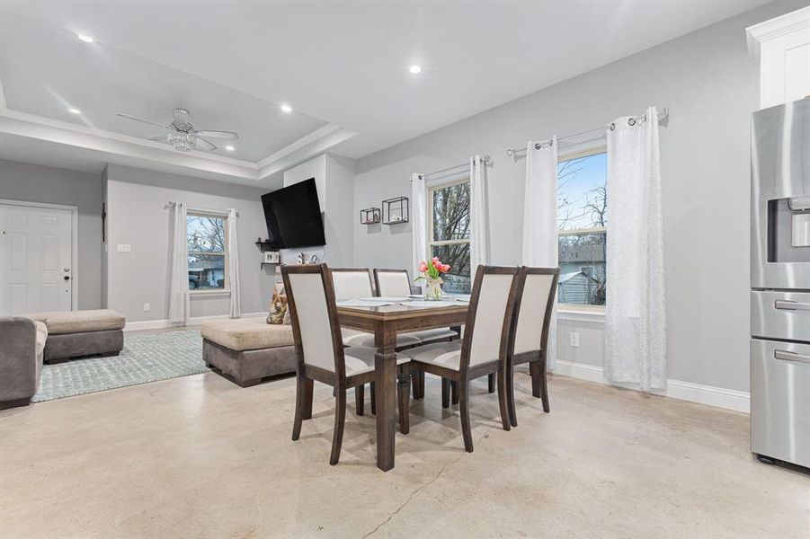 Dining room featuring a raised ceiling and ceiling fan