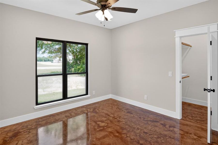 Room with polished concrete flooring, neutral wall paint, and white baseboards Room with polished concrete flooring, neutral wall paint, and white baseboards
