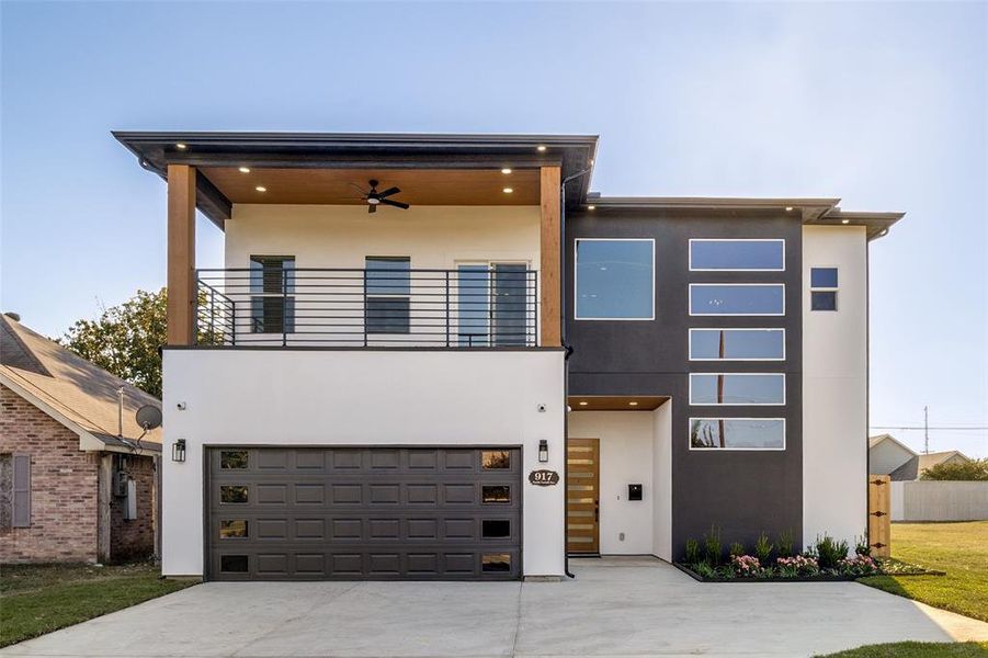 Contemporary house with driveway, stucco siding, a garage, a balcony, and ceiling fan Contemporary house with driveway, stucco siding, a garage, a balcony, and ceiling fan