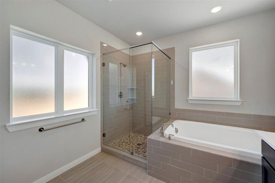 Bathroom featuring a shower stall, a garden tub, light tile patterned floors, vanity, and recessed lighting