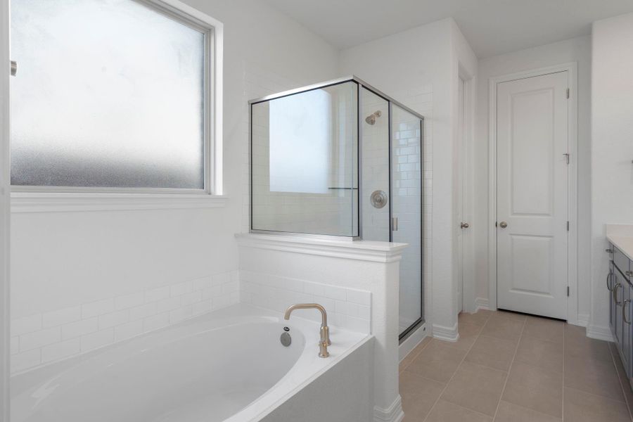 This additional view of your primary bathroom features tile flooring, fresh paint, walk-in shower, a separate garden tub, and a large walk-in closet. This additional view of your primary bathroom features tile flooring, fresh paint, walk-in shower, a separate garden tub, and a large walk-in closet.