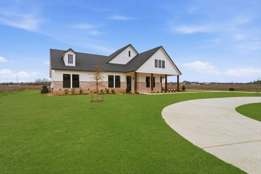 Front exterior of a new home in The Manors, New Waverly, TX, highlighting curb appeal (Image 22). Front exterior of a new home in The Manors, New Waverly, TX, highlighting curb appeal (Image 22).