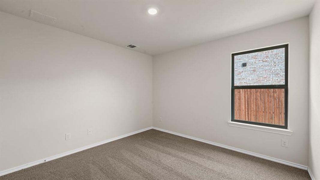Carpeted room with light neutral walls, a single window with dark trim, a white window sill, and a recessed ceiling light Carpeted room with light neutral walls, a single window with dark trim, a white window sill, and a recessed ceiling light