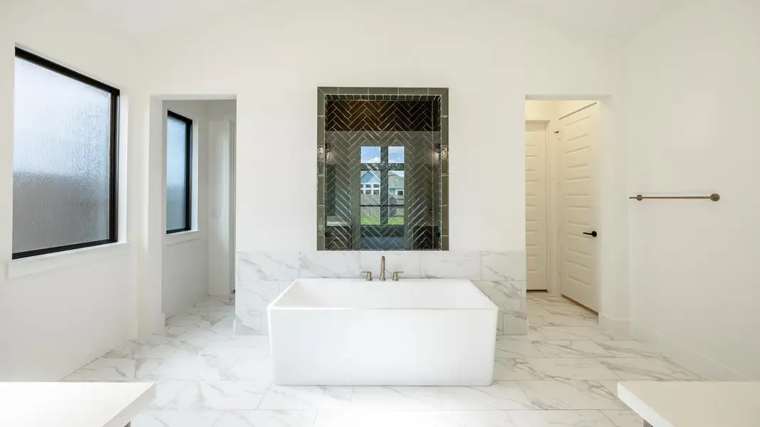 Full bathroom with a freestanding tub, vaulted ceiling, and light marble finish flooring Full bathroom with a freestanding tub, vaulted ceiling, and light marble finish flooring