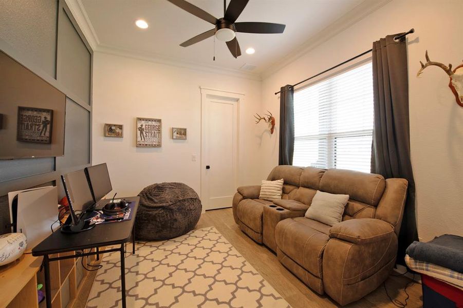 Living room with ornamental molding, light wood finished floors, a ceiling fan, recessed lighting, and an office area