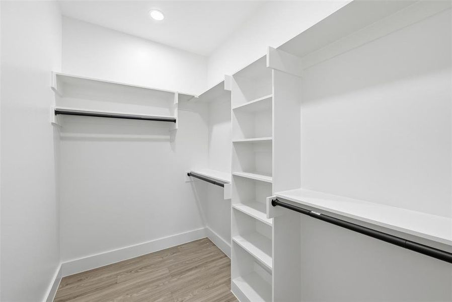 Spacious closet featuring light wood-style flooring Spacious closet featuring light wood-style flooring