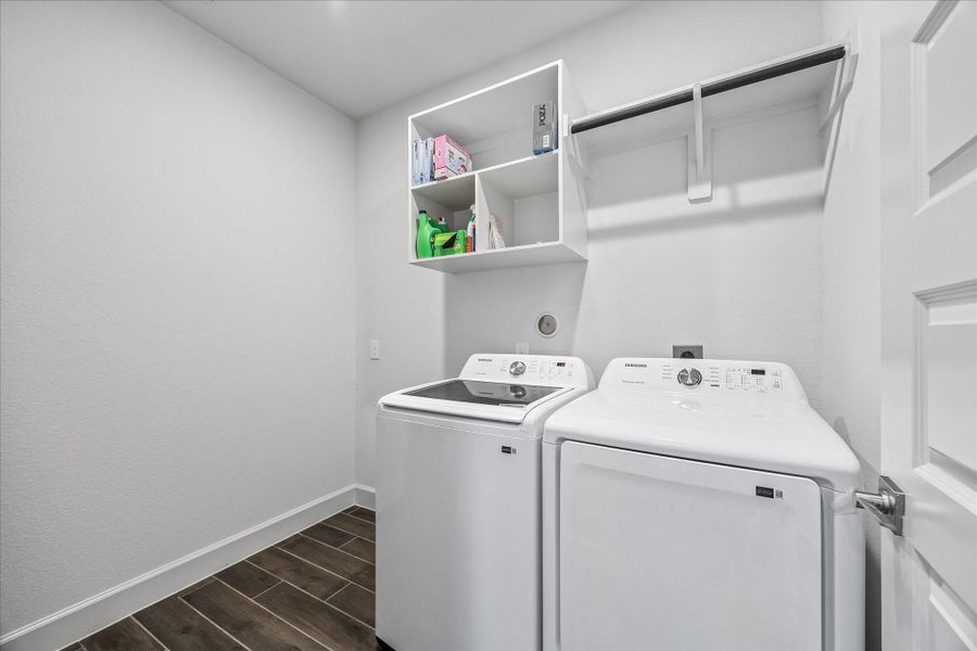 Dedicated utility room with upper shelving, hanging rod, and extra space for storage or organization