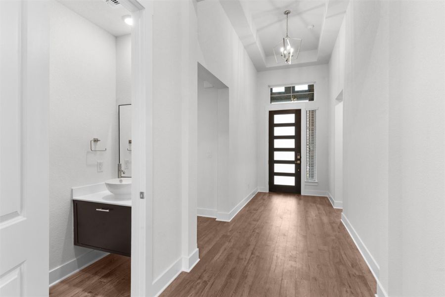 Entryway with a high ceiling, dark wood-style flooring, and a chandelier