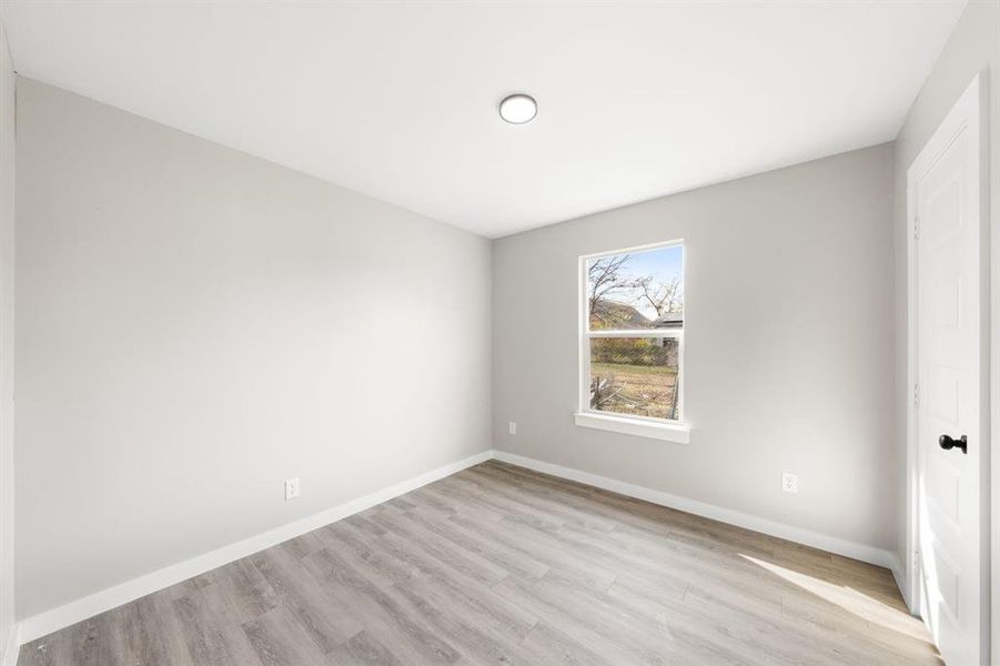 Empty room with baseboards and light wood-style floors Empty room with baseboards and light wood-style floors