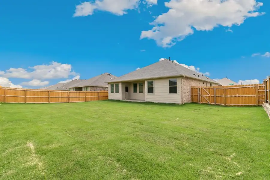 Back of property featuring a lawn