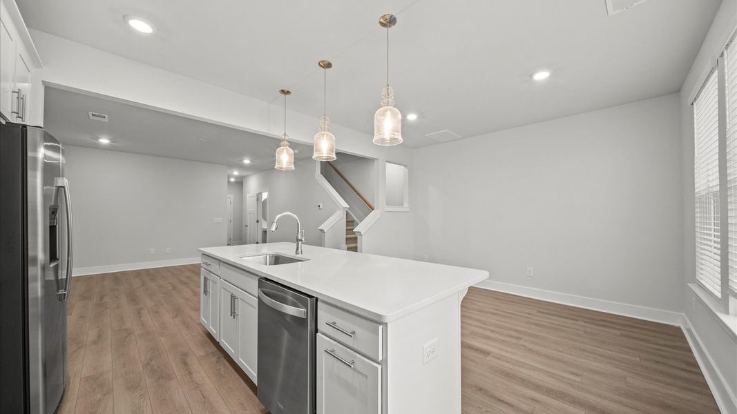 Accomplished kitchen design featuring pendant lighting above a statement island for both prep and gathering