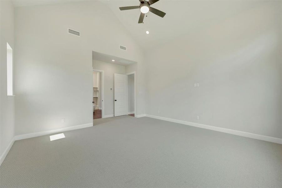 Spare room featuring light carpet, a ceiling fan, vaulted ceiling, and recessed lighting