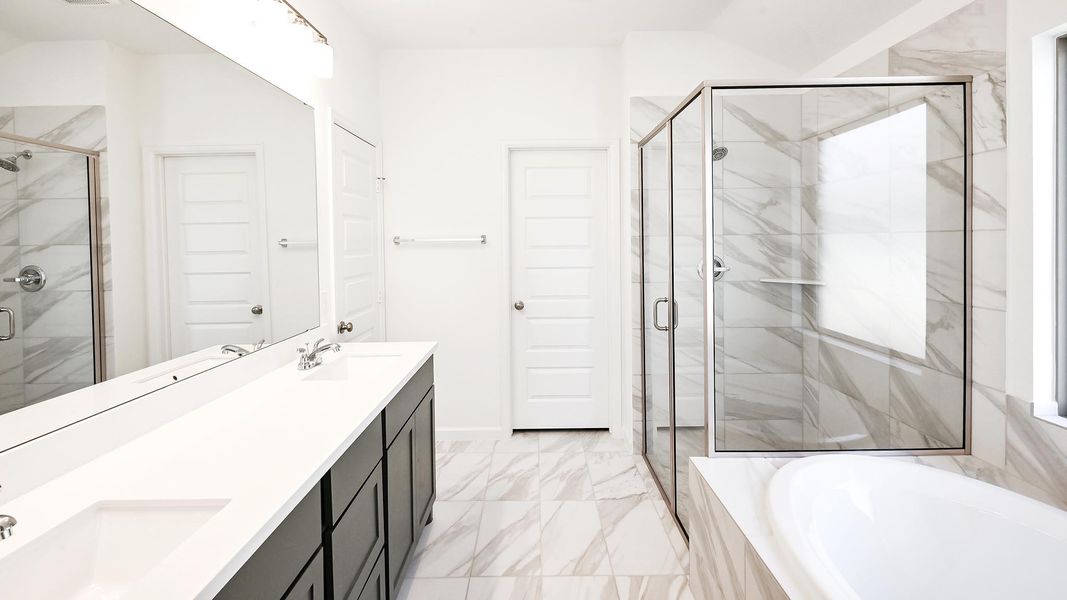 Full bath with a garden tub, double vanity, a stall shower, and marble finish floors Full bath with a garden tub, double vanity, a stall shower, and marble finish floors