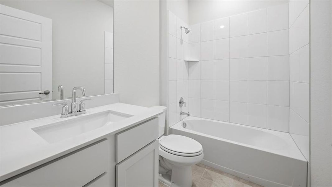 Bathroom featuring a spacious vanity with an integrated sink, polished chrome faucet, and a large mirror