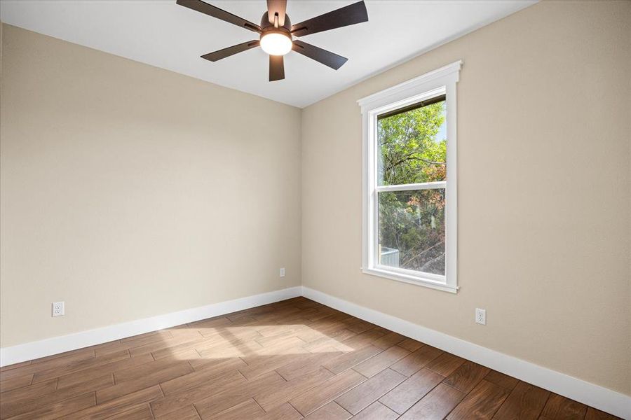 Unfurnished room featuring light wood-style flooring and a ceiling fan Unfurnished room featuring light wood-style flooring and a ceiling fan