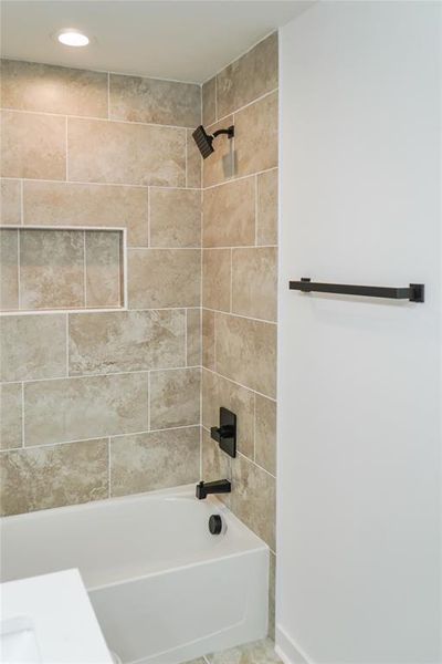 Full bathroom featuring shower / bath combination and baseboards Full bathroom featuring shower / bath combination and baseboards