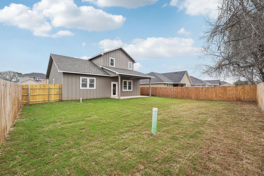 Back of property with a patio, a lawn, a fenced backyard, and roof with shingles Back of property with a patio, a lawn, a fenced backyard, and roof with shingles