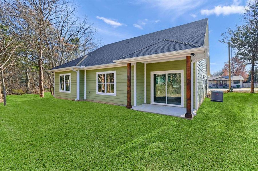 Back of property featuring a yard and a patio